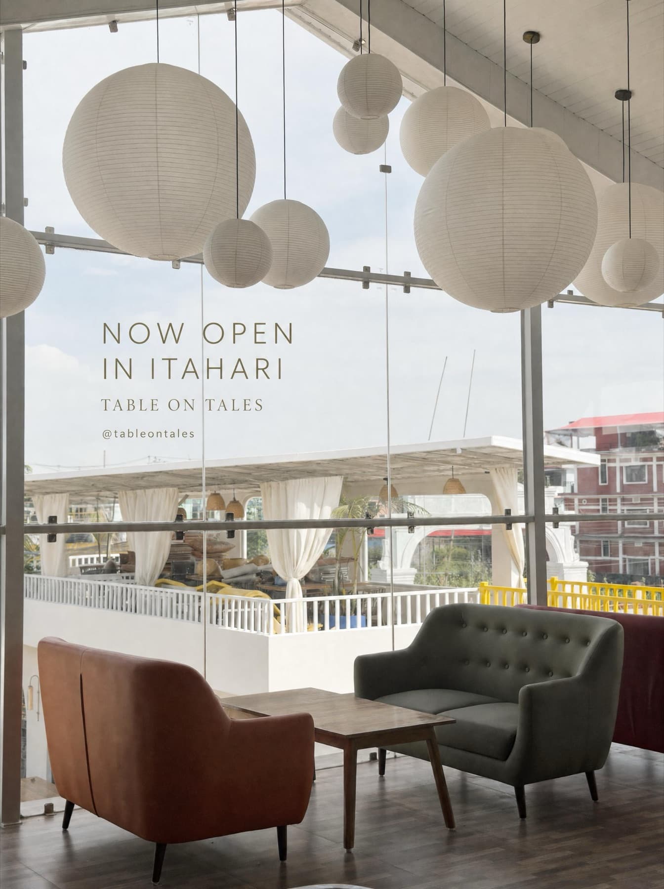Lounge seating beneath hanging paper lanterns by the glass wall